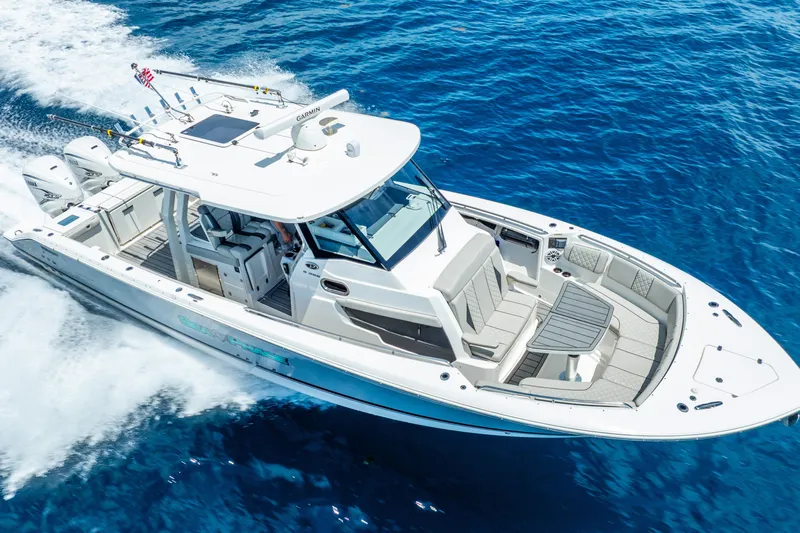 Sea Phase Yacht Photos Pics 2024 Pursuit S 358 Sport boat cruising on clear blue ocean waters.