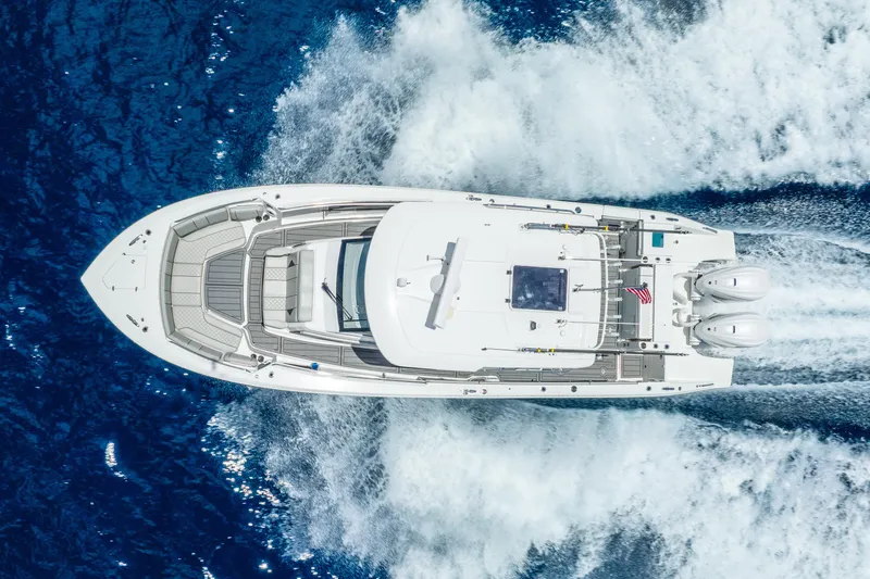 Sea Phase Yacht Photos Pics 2024 Pursuit S 358 Sport boat cruising on blue ocean waters, aerial view.