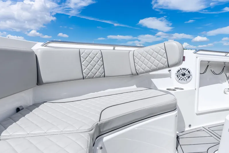 Sea Phase Yacht Photos Pics 2024 Pursuit S 358 Sport boat interior with luxurious seating and speaker, under a clear blue sky.