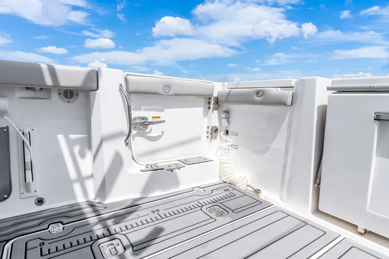 Sea Phase Yacht Photos Pics 2024 Pursuit S 358 Sport boat deck with storage and seating under a blue sky.