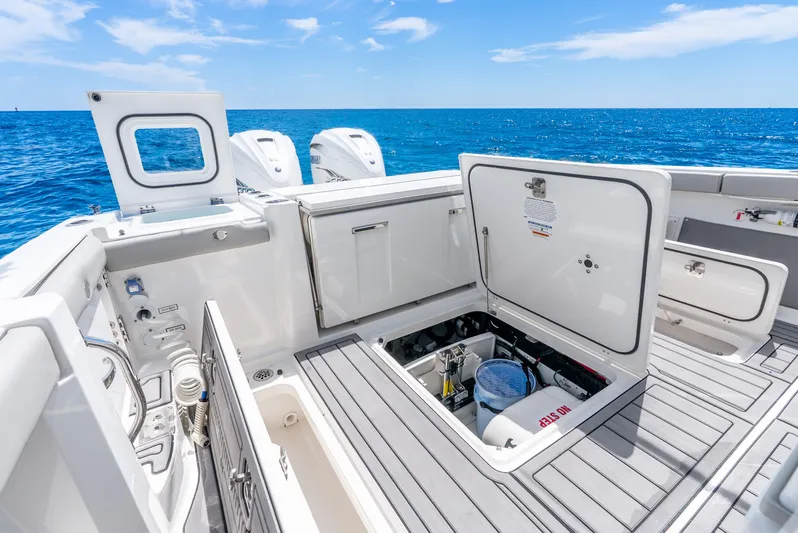 Sea Phase Yacht Photos Pics 2024 Pursuit S 358 Sport boat deck with open storage compartments, ocean view.