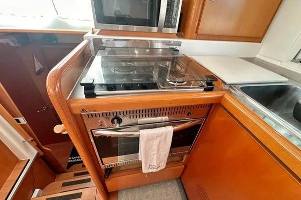 Brizo Yacht Photos Pics 2006 Lagoon 440 yacht kitchen with stove, oven, and microwave in wooden cabinetry.