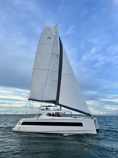  Yacht Photos Pics Sailing catamaran Aventura 45, 2026 model, gliding on open sea under a clear sky.