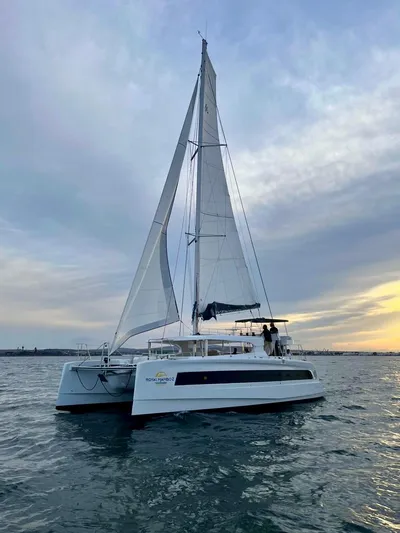  Yacht Photos Pics Aventura 45 catamaran sailing at sunset, 2026 model, on calm waters.