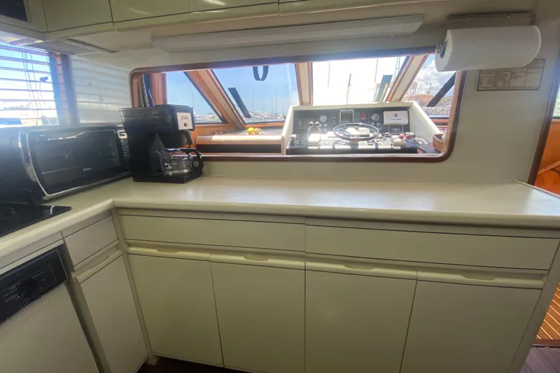 Sea Sharp Yacht Photos Pics Interior of 1990 Viking 63 Motor Yacht kitchen with appliances and helm view.
