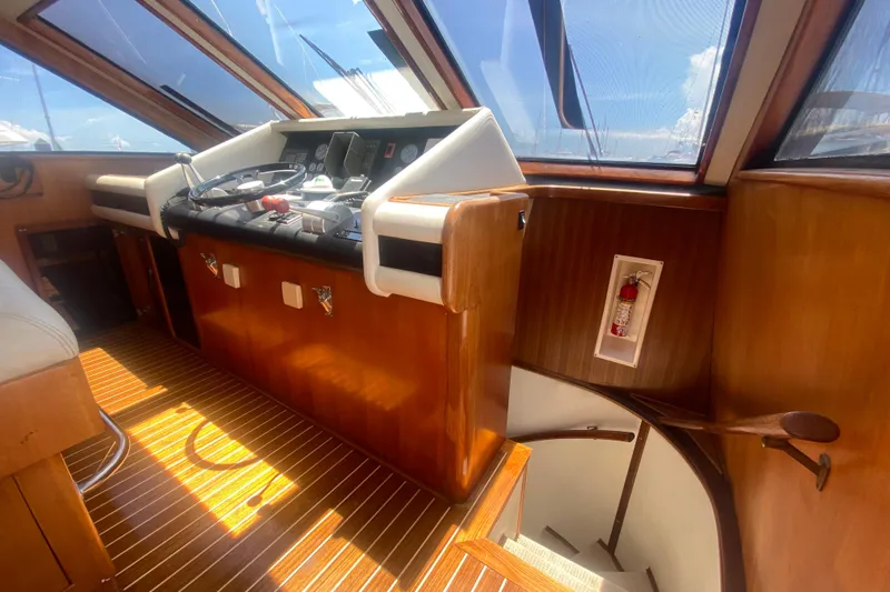 Sea Sharp Yacht Photos Pics Interior helm of 1990 Viking 63 Motor Yacht with wooden finish and steering controls.
