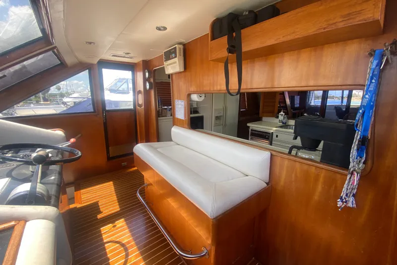 Sea Sharp Yacht Photos Pics Interior of 1990 Viking 63 Motor Yacht with wooden paneling and white seating.