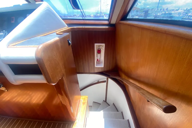 Sea Sharp Yacht Photos Pics Interior of 1990 Viking 63 Motor Yacht with wooden stairs and fire extinguisher.
