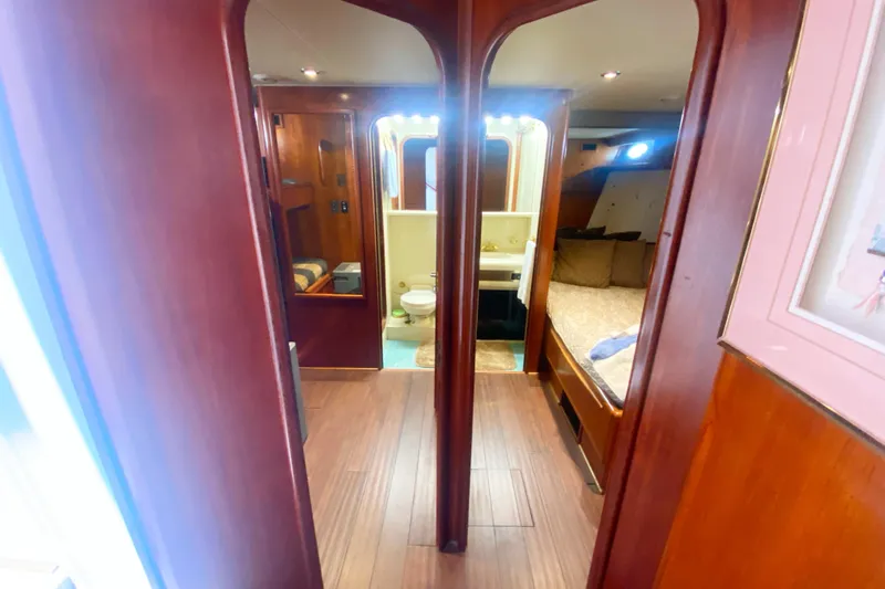 Sea Sharp Yacht Photos Pics Interior of 1990 Viking 63 Motor Yacht with wood paneling, bedroom, and bathroom.