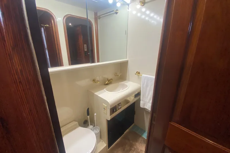 Sea Sharp Yacht Photos Pics Luxurious bathroom in a 1990 Viking 63 Motor Yacht with elegant wood accents.