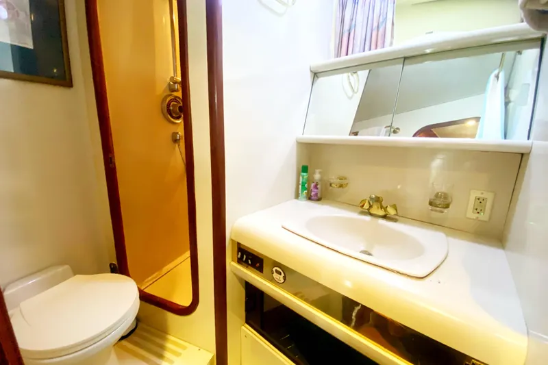 Sea Sharp Yacht Photos Pics Bathroom interior of 1990 Viking 63 Motor Yacht with sink, mirror, and shower.