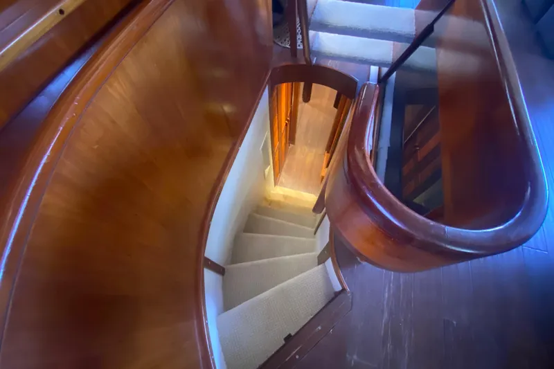 Sea Sharp Yacht Photos Pics Curved wooden staircase inside a 1990 Viking 63 Motor Yacht.