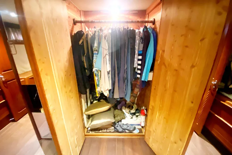 Sea Sharp Yacht Photos Pics Wooden closet with clothes and shoes inside a 1990 Viking 63 Motor Yacht.