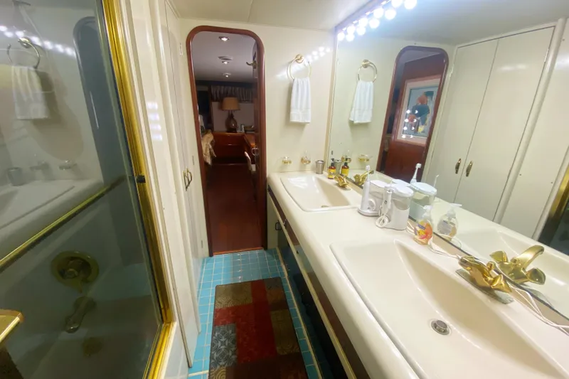 Sea Sharp Yacht Photos Pics Luxurious bathroom in 1990 Viking 63 Motor Yacht with double sinks and gold fixtures.