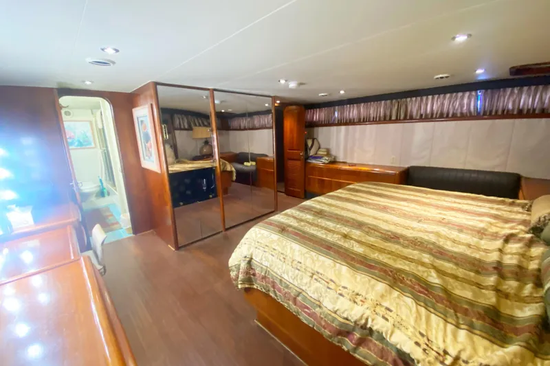 Sea Sharp Yacht Photos Pics Luxurious bedroom interior of a 1990 Viking 63 Motor Yacht with elegant wood finishes.