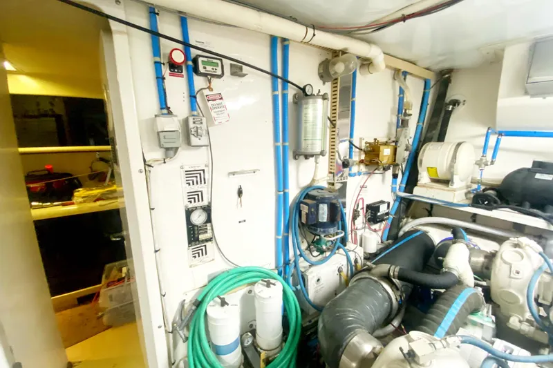 Sea Sharp Yacht Photos Pics Engine room of 1990 Viking 63 Motor Yacht with various mechanical components and blue piping.