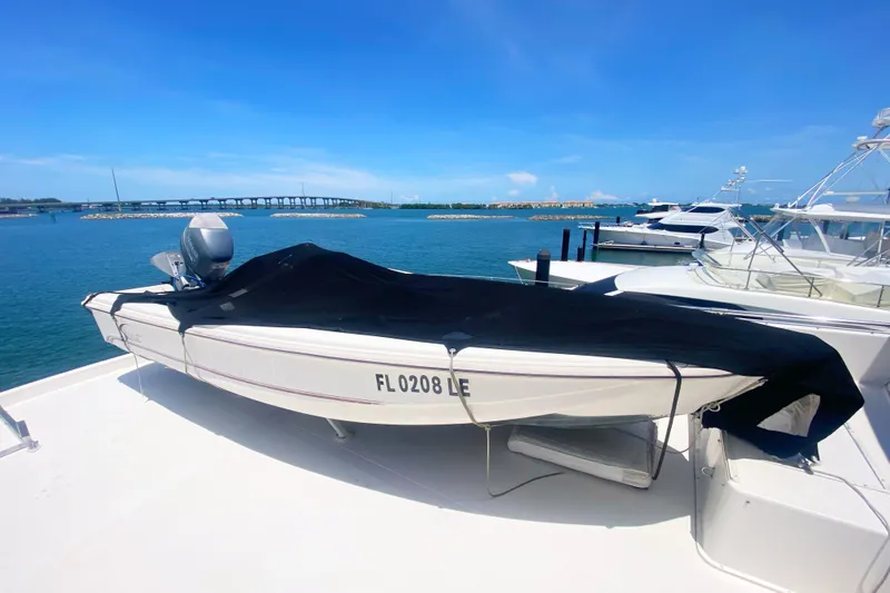 Sea Sharp Yacht Photos Pics 1990 Viking 63 Motor Yacht with covered boat on deck, docked by a scenic waterfront.