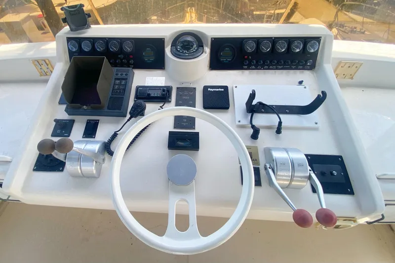 Sea Sharp Yacht Photos Pics Control panel of a 1990 Viking 63 Motor Yacht with steering wheel and navigation instruments.