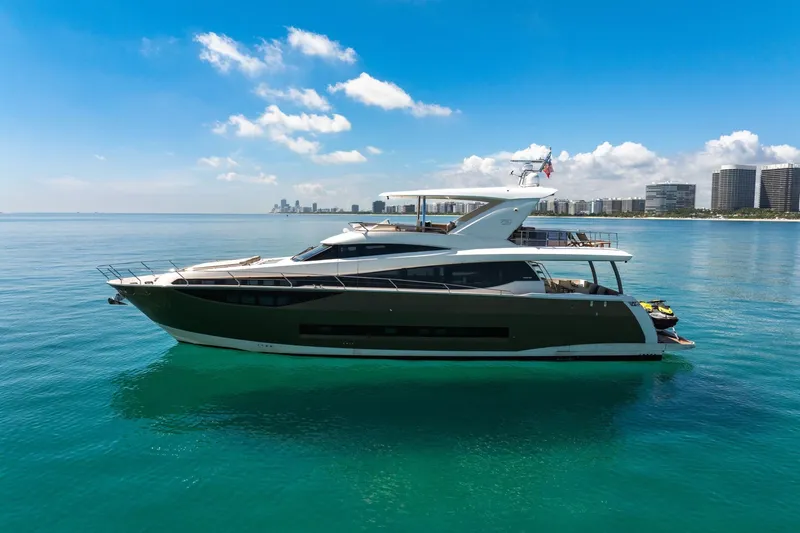 Oceana Yacht Photos Pics Luxurious 2015 Prestige 750 yacht cruising on clear blue waters near a city skyline.