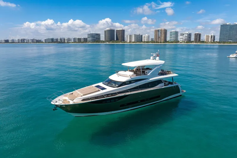 Oceana Yacht Photos Pics Luxurious 2015 Prestige 750 yacht cruising in clear blue waters near a city skyline.