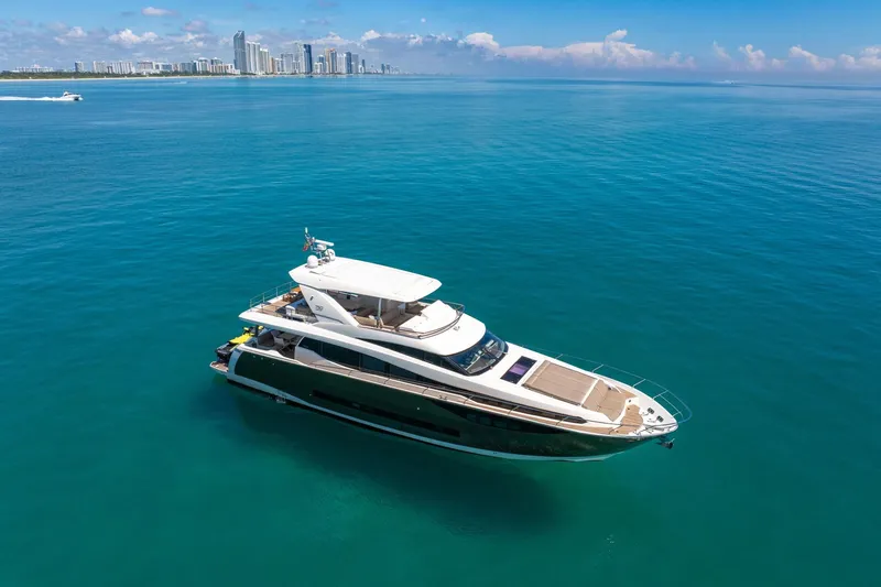 Oceana Yacht Photos Pics Luxurious 2015 Prestige 750 yacht cruising in clear blue waters near a city skyline.