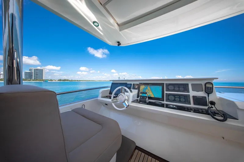 Oceana Yacht Photos Pics Helm of 2015 Prestige 750 yacht with navigation screens, overlooking ocean and skyline.