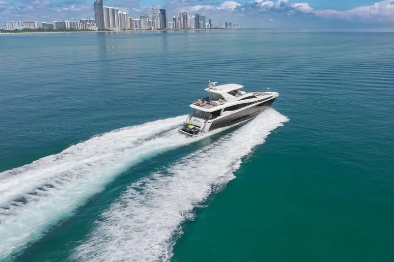 Oceana Yacht Photos Pics Luxury yacht Prestige 750 cruising on clear blue ocean near city skyline, 2015 model.