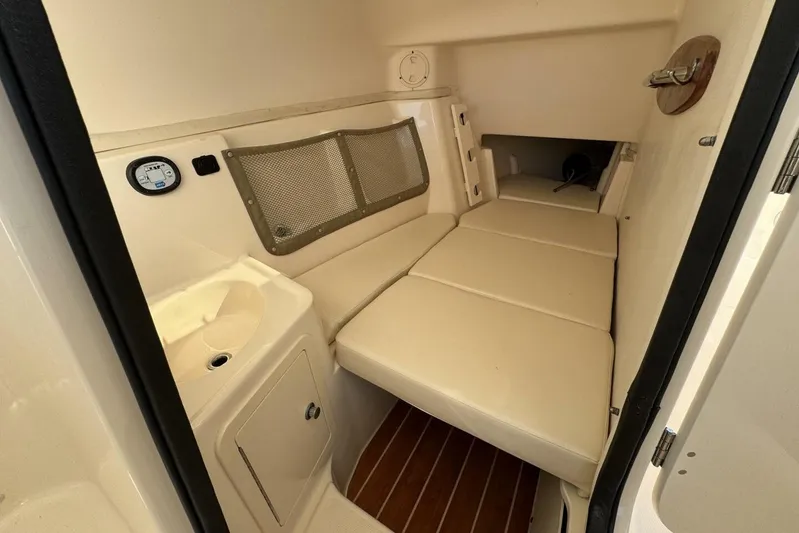 Yacht Photos Pics 2016 Grady-White Freedom 307 cabin interior with cushioned seating and storage.