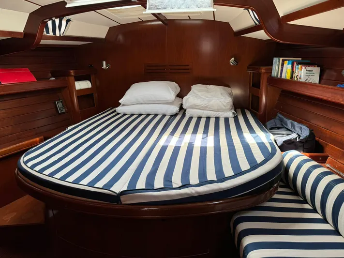  Yacht Photos Pics Luxurious cabin interior of 2004 Beneteau 50 yacht with striped bedding and wooden finish.