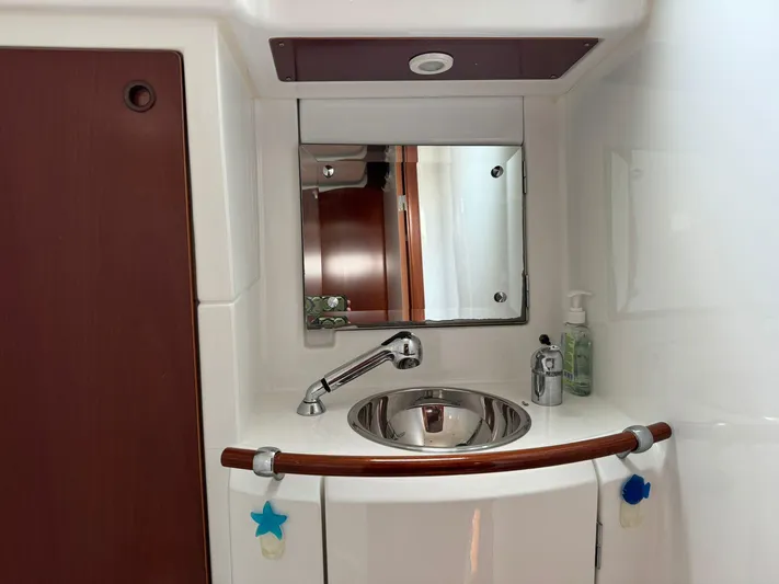  Yacht Photos Pics Bathroom sink area in a 2004 Beneteau 50 yacht, featuring a mirror and faucet.