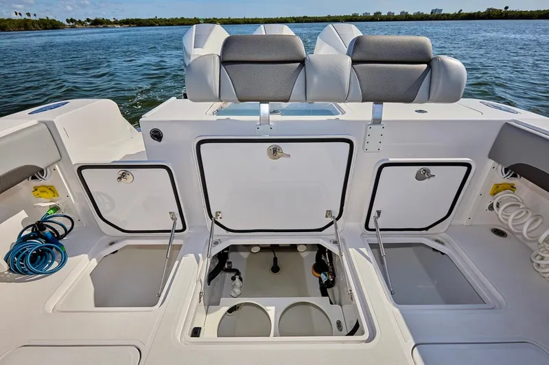  Yacht Photos Pics 2022 Bluewater 35 boat with open storage compartments on deck, docked on calm water.