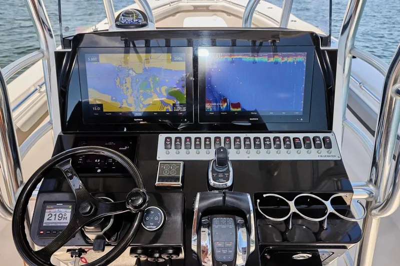  Yacht Photos Pics Control panel of 2022 Bluewater 35 boat with navigation screens and steering wheel.