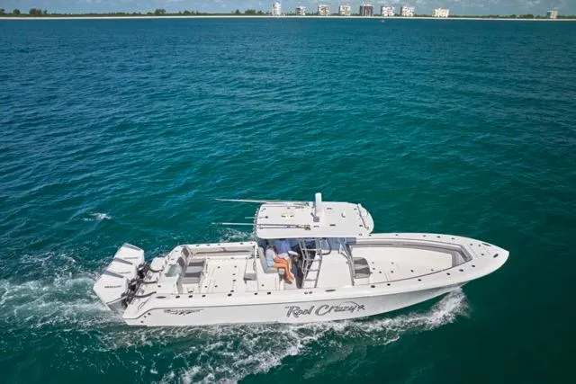  Yacht Photos Pics Bluewater 35 boat cruising on open water, 2022 model, with clear blue sea and distant buildings.