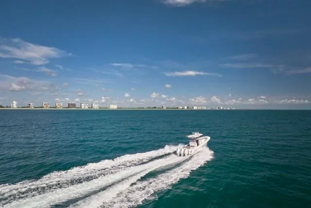  Yacht Photos Pics 2022 Bluewater 35 boat cruising on open ocean with coastal skyline in background.