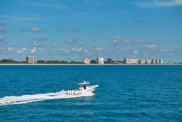  Yacht Photos Pics 2022 Bluewater 35 boat cruising on blue ocean with city skyline in background.