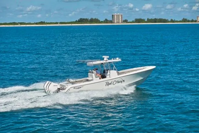  Yacht Photos Pics 2022 Bluewater 35 boat cruising on blue ocean near coastline under clear sky.