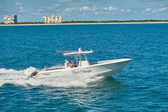  Yacht Photos Pics 2022 Bluewater 35 boat cruising on blue ocean near coastline buildings.