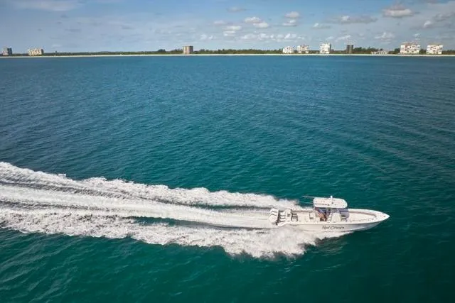  Yacht Photos Pics Bluewater 35 boat cruising on open water, 2022 model, with coastal buildings in the background.