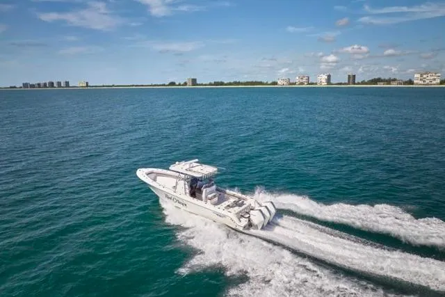  Yacht Photos Pics 2022 Bluewater 35 boat cruising on open water with coastal buildings in the background.