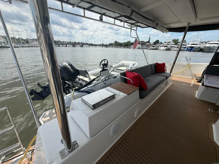 Darla Jay Yacht Photos Pics 2023 Fountaine Pajot Aura 51 yacht deck with seating, red cushions, and water view.