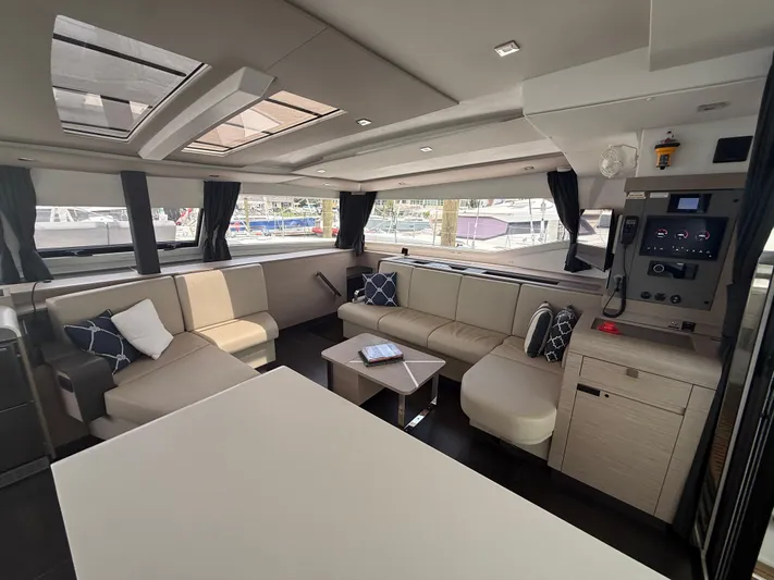 Darla Jay Yacht Photos Pics Luxurious interior of 2023 Fountaine Pajot Aura 51 catamaran with modern seating and large windows.