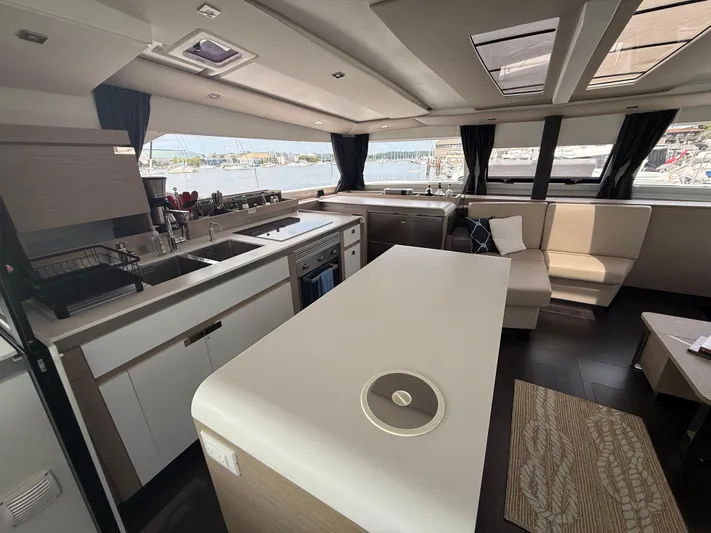 Darla Jay Yacht Photos Pics Luxurious interior of 2023 Fountaine Pajot Aura 51 catamaran with modern kitchen and seating area.