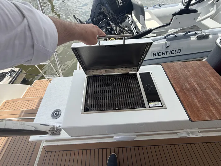 Darla Jay Yacht Photos Pics Outdoor grill on 2023 Fountaine Pajot Aura 51 yacht deck, near water and boat equipment.