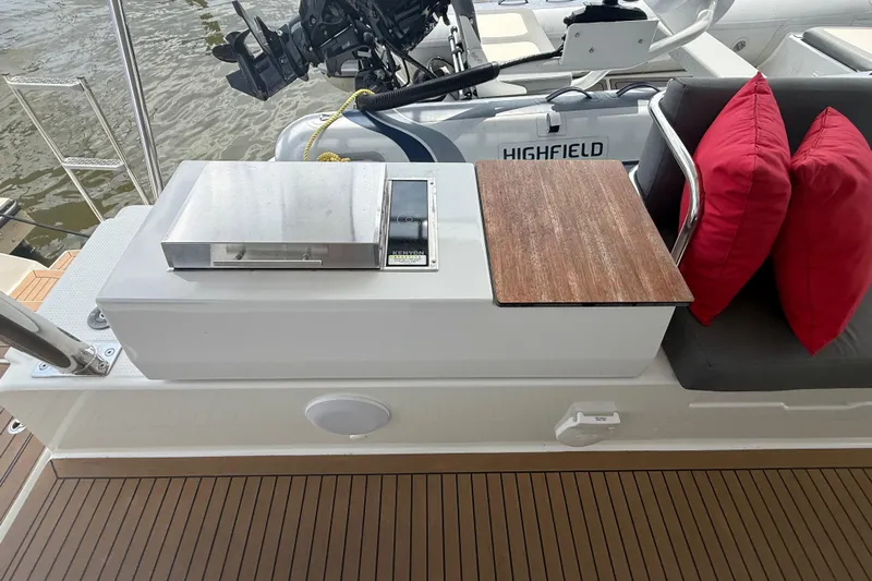 Darla Jay Yacht Photos Pics 2023 Fountaine Pajot Aura 51 yacht deck with grill, seating, and red cushions.