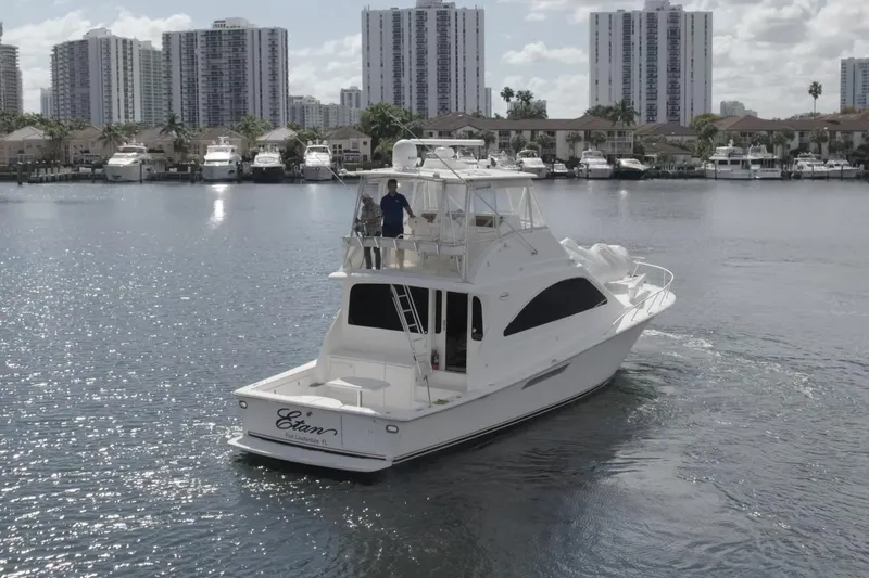 Etan Yacht Photos Pics 2005 Ocean Yachts 50 Super Sport cruising in a marina with city skyline backdrop.