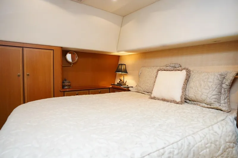 Etan Yacht Photos Pics Luxurious bedroom interior of 2005 Ocean Yachts 50 Super Sport with elegant bedding and warm lighting.