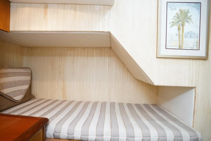 Etan Yacht Photos Pics Cozy cabin interior of 2005 Ocean Yachts 50 Super Sport with striped bedding and wall art.