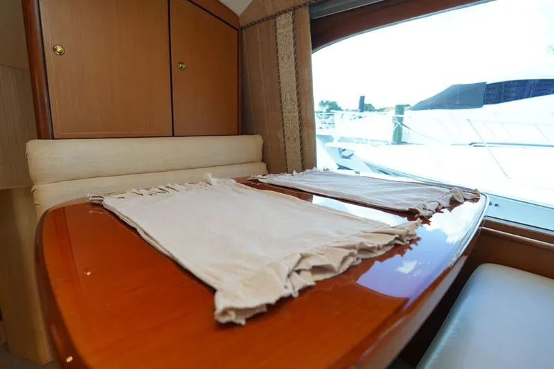 Etan Yacht Photos Pics Interior of 2005 Ocean Yachts 50 Super Sport with wooden table and window view.
