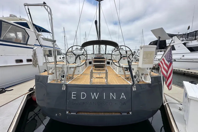  Yacht Photos Pics 2018 Jeanneau 54 yacht docked, rear view with dual steering wheels and American flag.