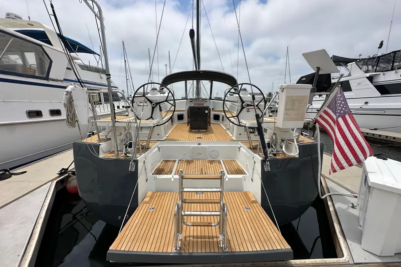  Yacht Photos Pics 2018 Jeanneau 54 sailboat docked, featuring dual steering wheels and American flag.